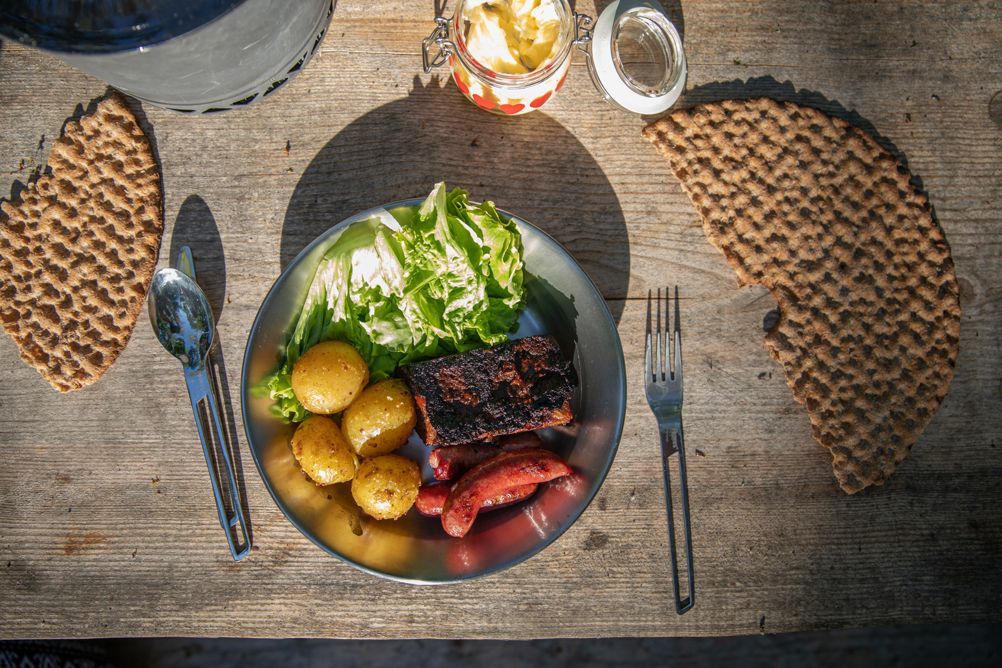 Tallrik med mat på bord ute i naturen