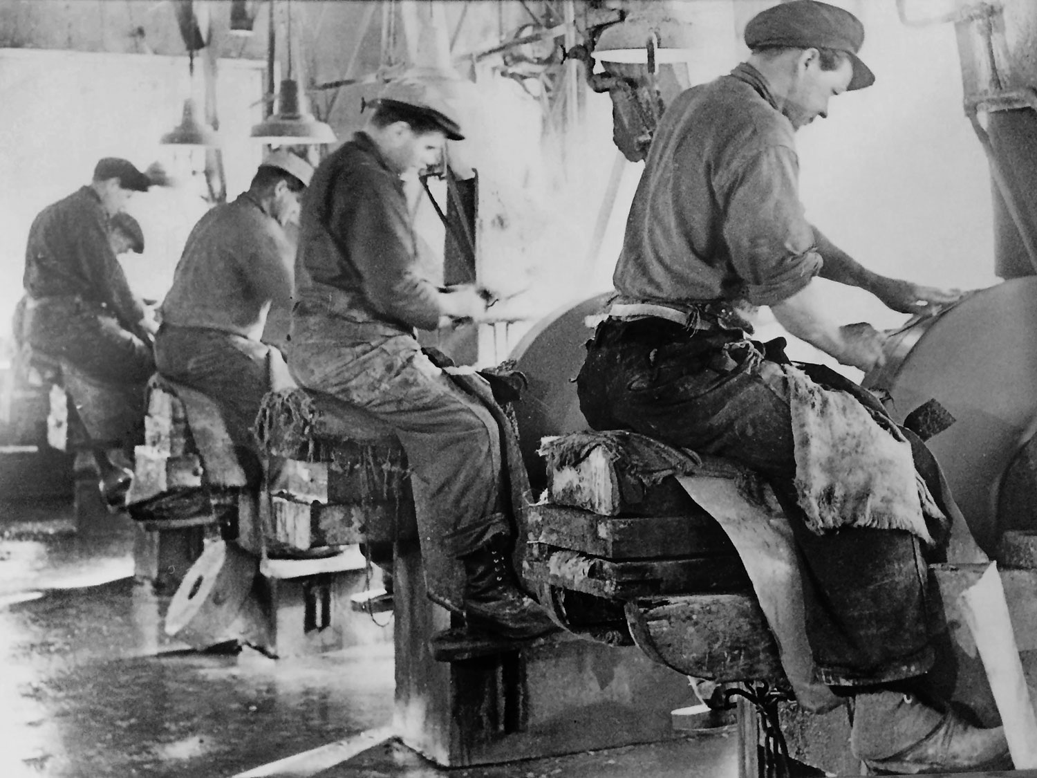 Arbetare vid slipbockar i Moraknivs knivfabrik.