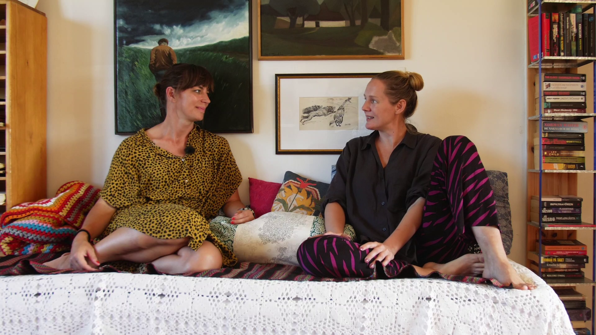 Isabelle McAllister och Lina Thomsgård sitter i en soffa och pratar.