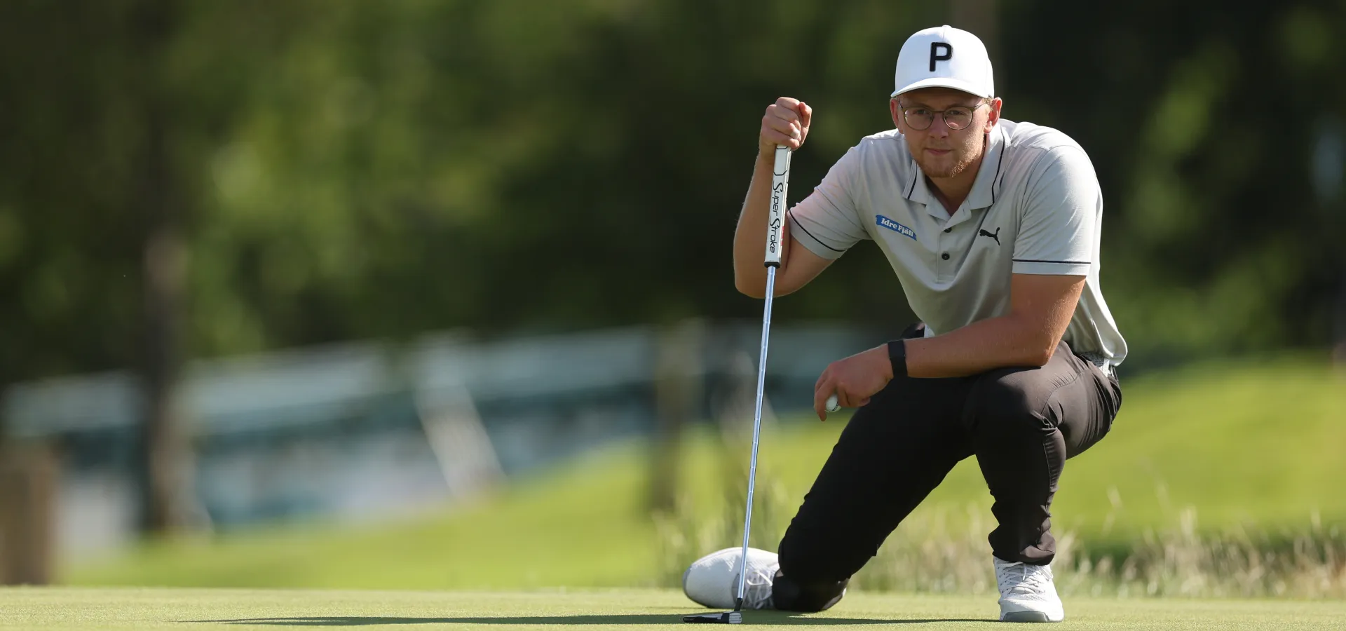 Rasmus Lia sitter på huk på golfbanan.