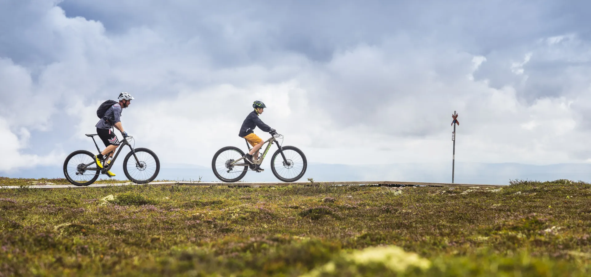 Vuxen och barn cyklar på fjället i Sälen, längs en av Biking Dalarnas cykelleder.