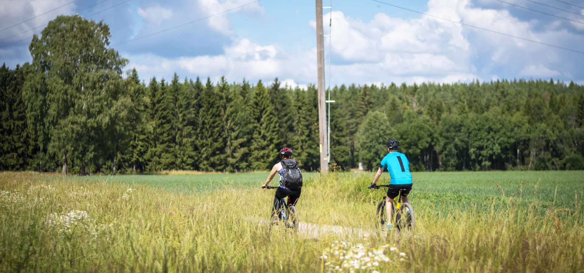 Två cyklister längs vägen på Dalhallarundan.