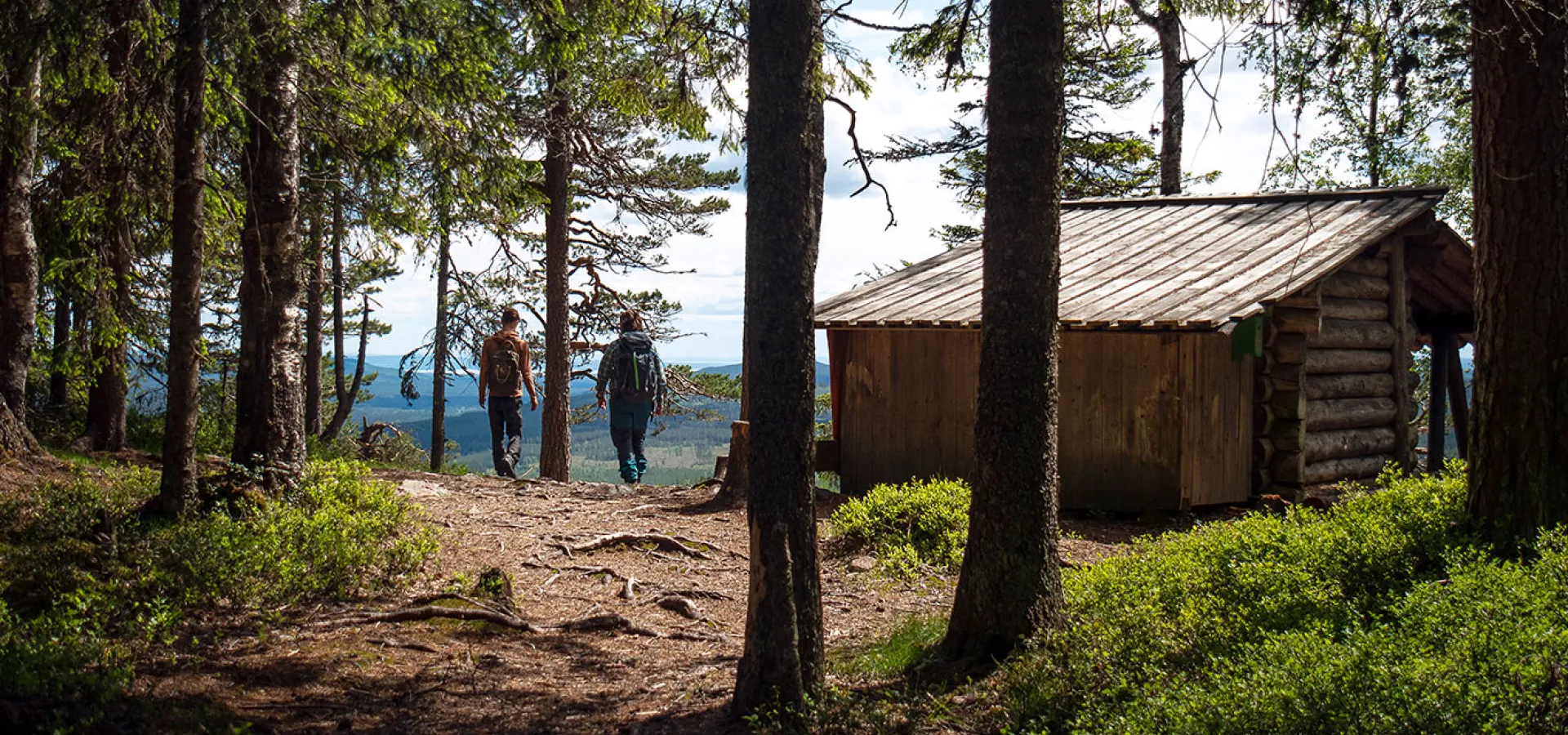 Två personer vid slogboden på toppen av Hykjeberg i Älvdalen.