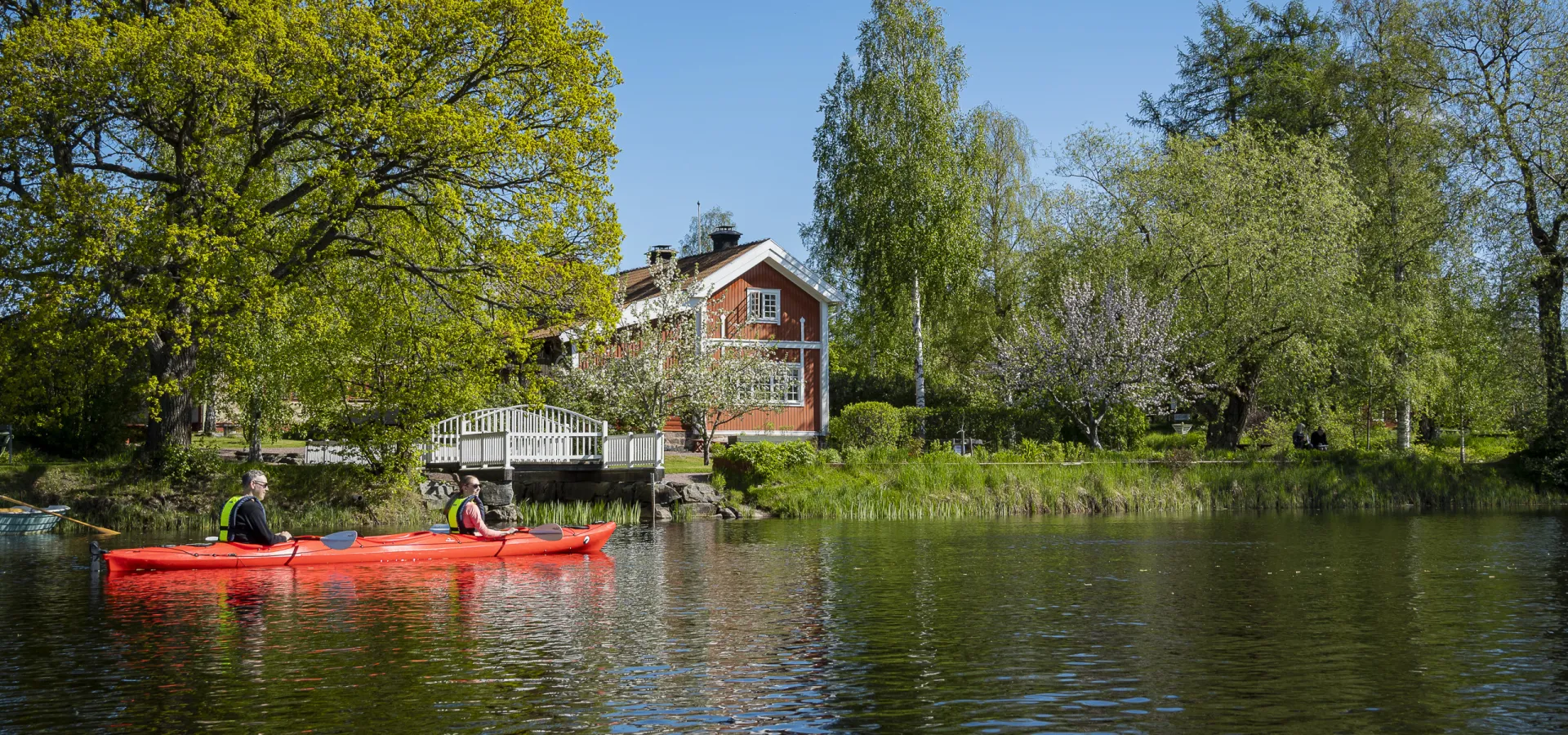 En person som paddlar kajak på sjö.