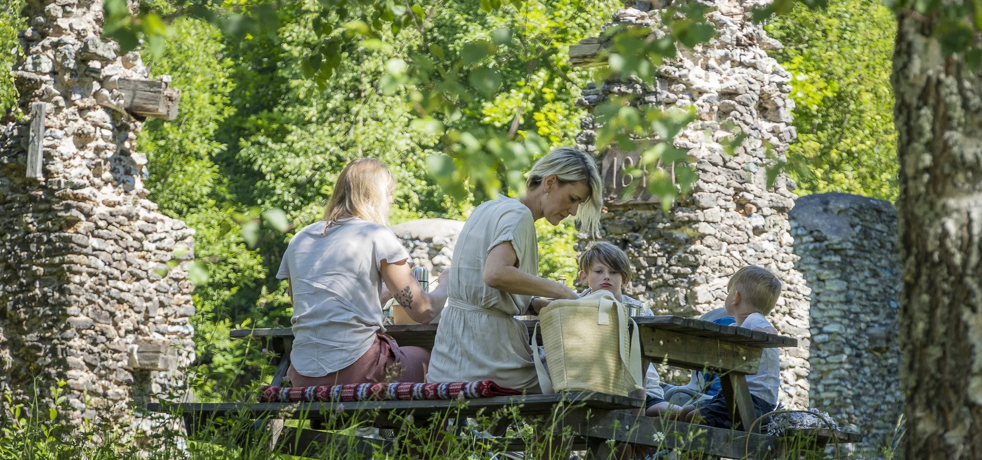 En familj njuter av picknick utomhus.