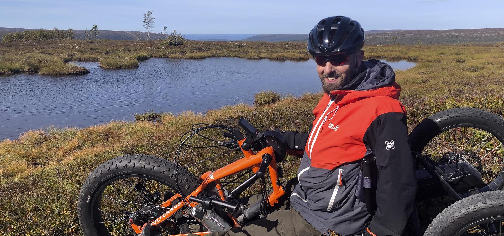 Fredrik Lindström vilar i lingonriset med trehjulig cykel. 