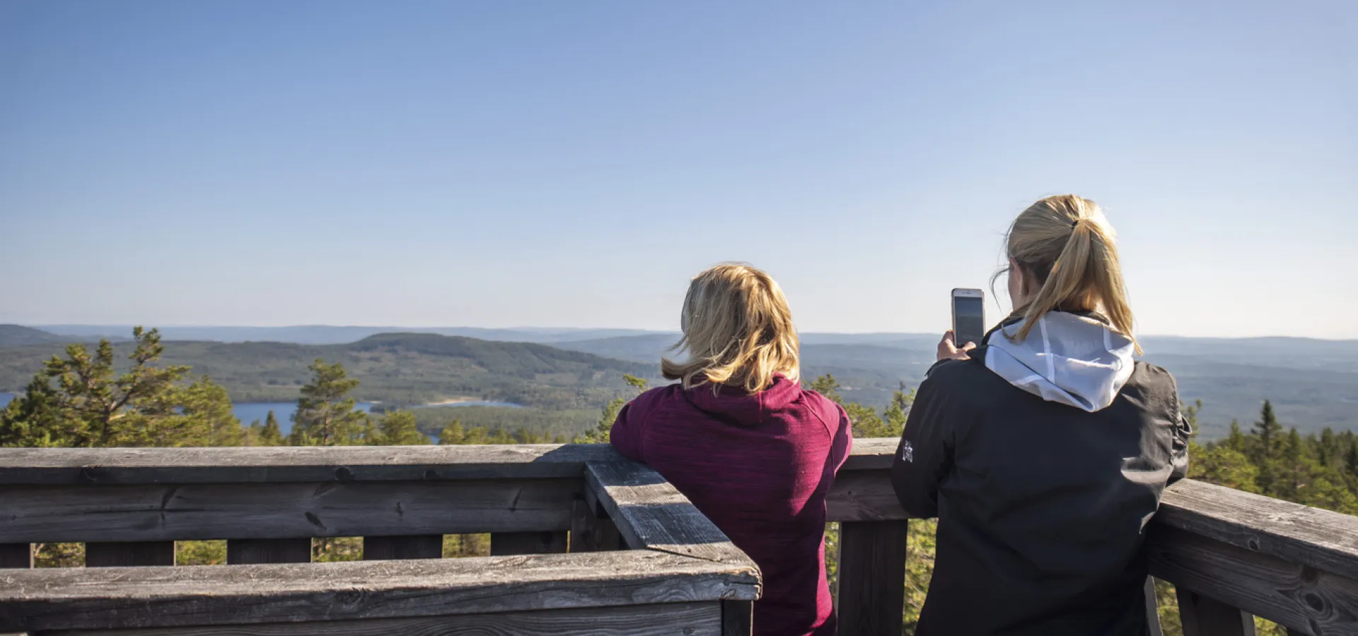 Två personer i utsiktstornet på toppen av Skinnaråsen i Leksand.