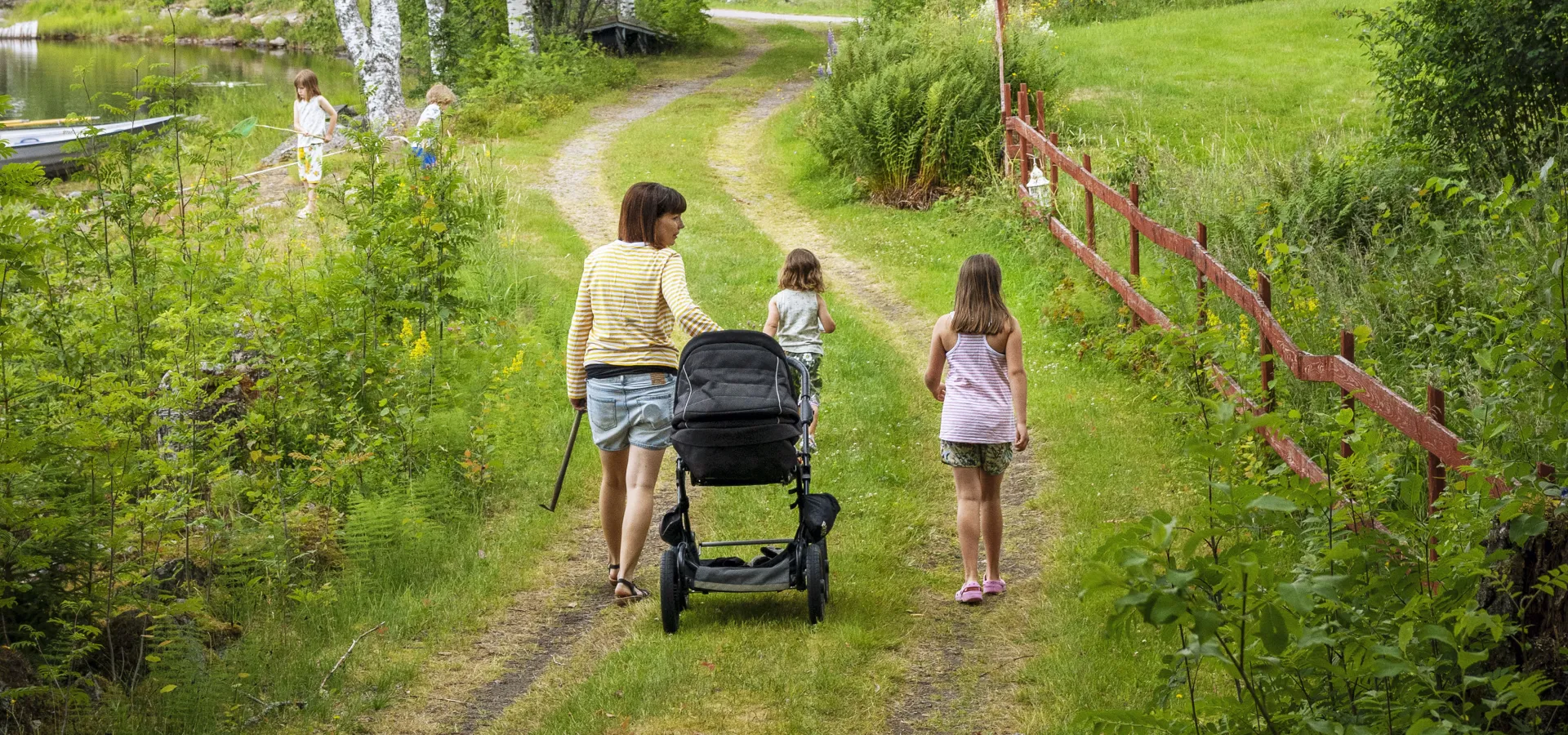 Familj som vandrar längs en grusväg.