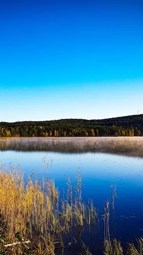 En spegelblank sjö med höstfärger. 