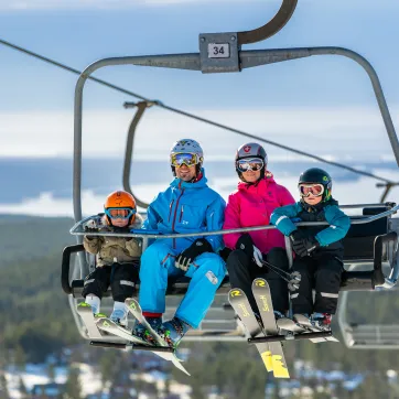 Family sitting on chairlift on Orsa Grönklitt.