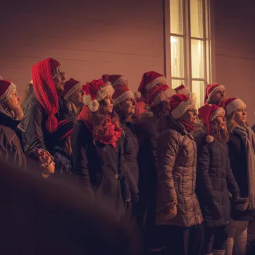 Kör med tomteluvor på huvudet som sjunger.