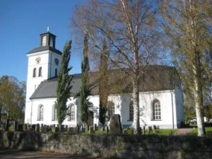 Vit kyrka med torn och höga fönster.
