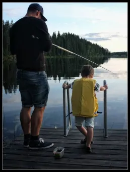  A father and a child fishing from a jetty.