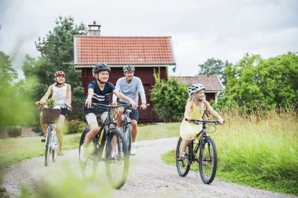Familj som cyklar på en grusväg.