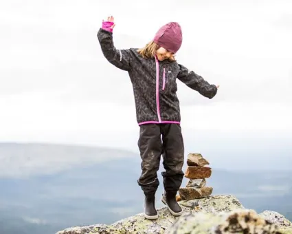 En flicka som står på en sten.
