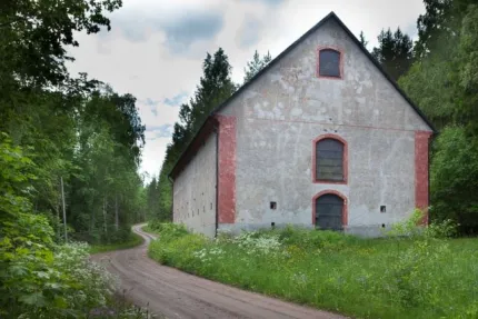 Grå vacker industribyggnad i sommarlandskap.