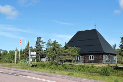 The church with greenery around and the country road next to it.
