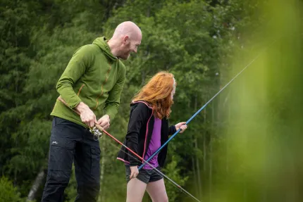 En fiskande man med en flicka.