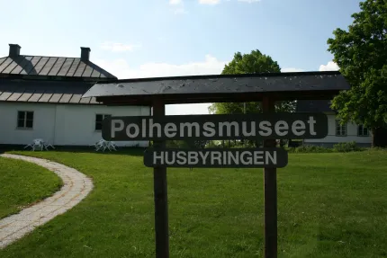 Sign outside the museum that says Polhemsmuseet Husbyringen.