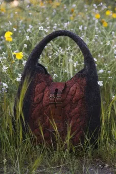En tovad väska som står bland blommor på en äng.