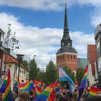 Mora kyrka med regnbågsflaggor framför.