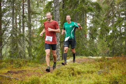 Två män som springer i en skog.