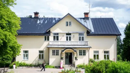 En vit villa med svart tak.