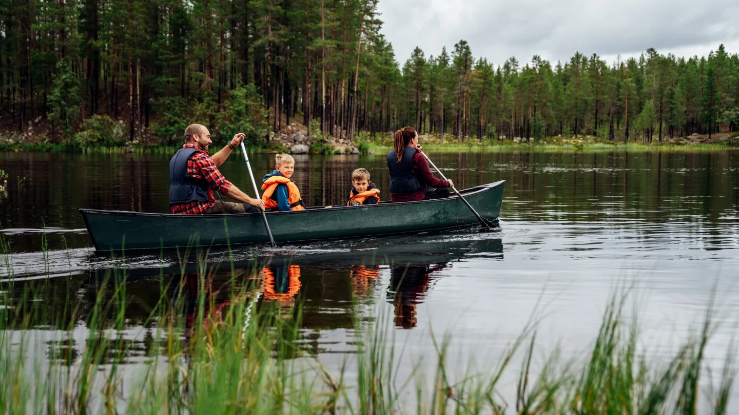 Familj och paddlar kanot.