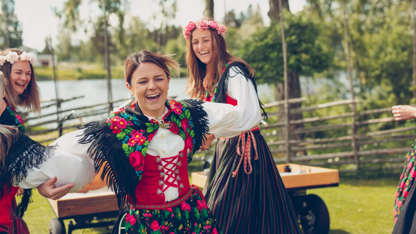 Tjejer i folkdräkter under ett midsommarfirande.